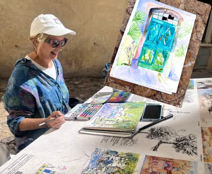 Parcours Croquez Sauve. Photo d'une peintre en action avec boîte d'aquarelles et carnet à dessin posés sur la table explicative du parcours.